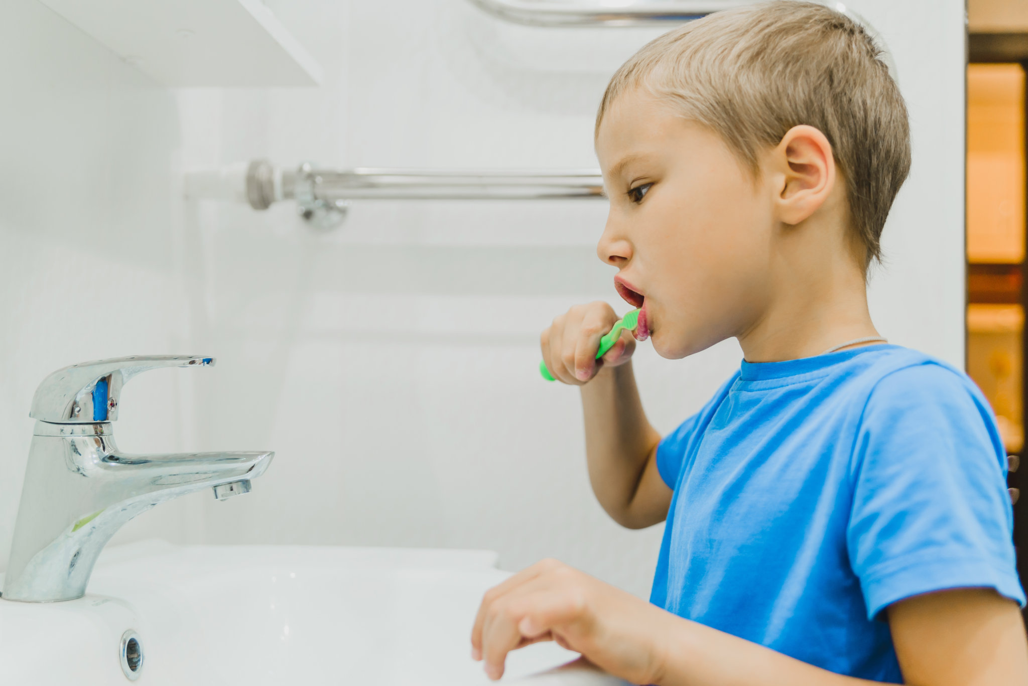 A child brushes his teeth with a toothbrush in the bathroom. prevention